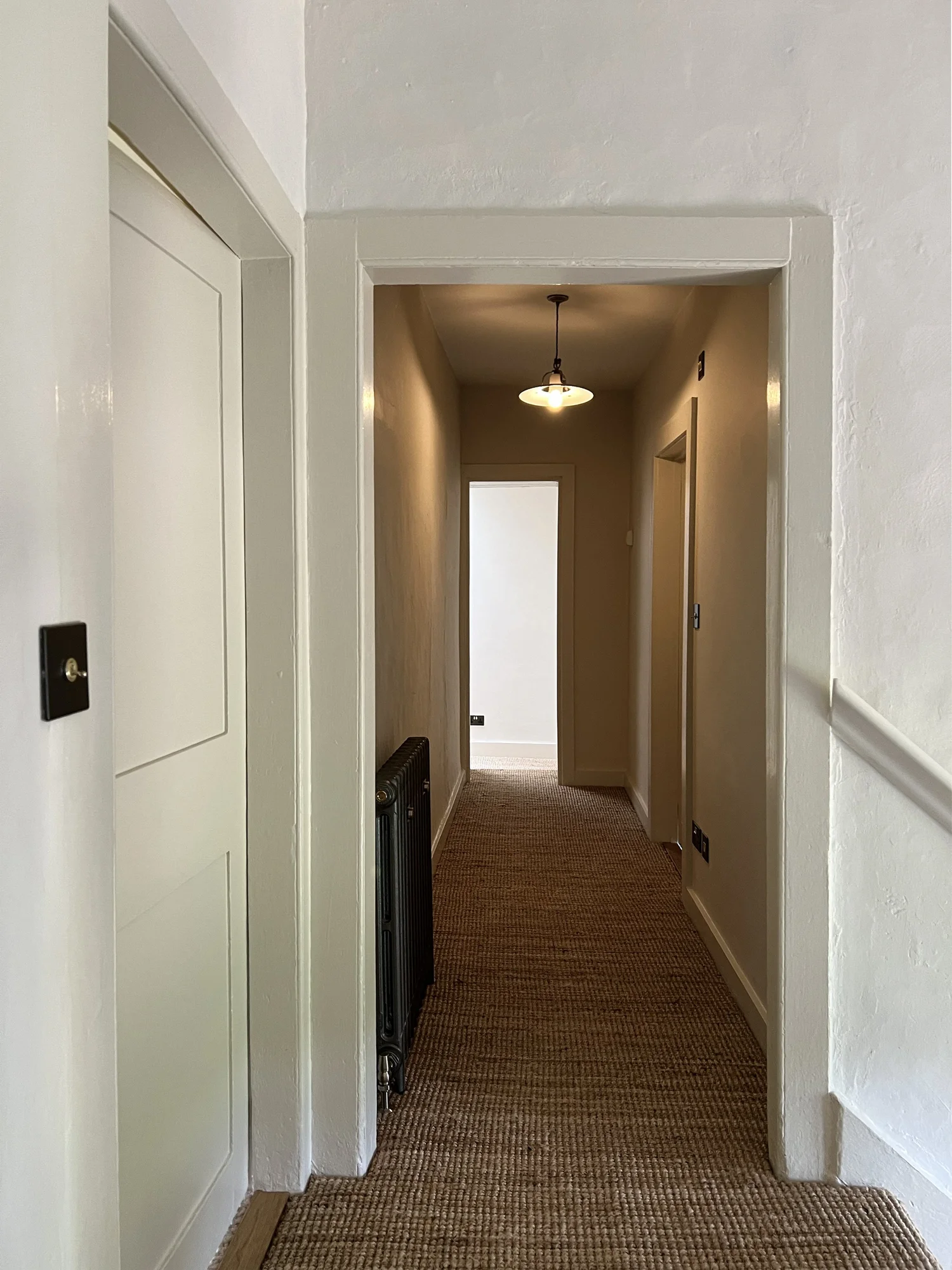 Lobby with lime-plastered fireplace connecting kitchen and sitting room